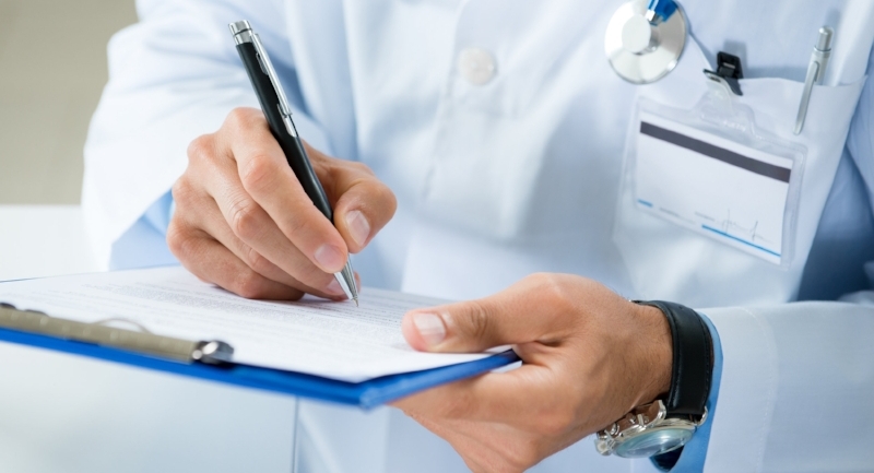 Doctor writing on a clipboard